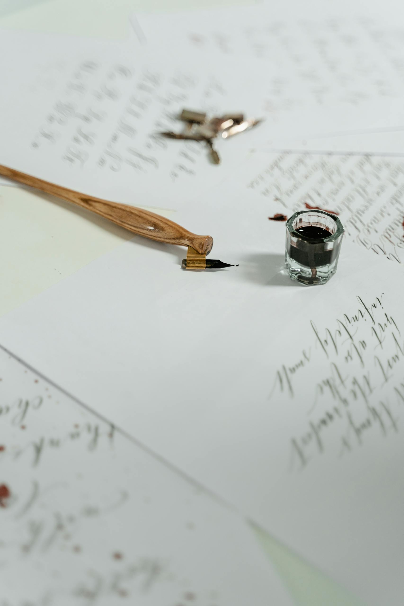 A graceful still life of handwritten calligraphy with a quill pen and ink on paper, showcasing artistic elegance.